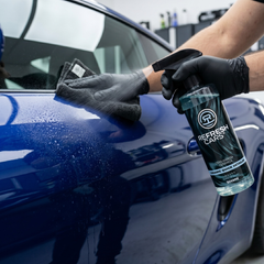 Cera híbrida cerámica Refresh Cars pulverizada sobre carrocería azul con guante de nitrilo