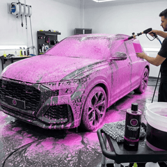 Champú de espuma rosa Refresh Cars aplicado con lanza sobre SUV negro en taller de detailing