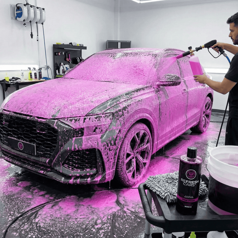 Champú de espuma rosa Refresh Cars aplicado con lanza sobre SUV negro en taller de detailing