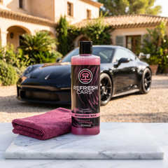 Champú prelavado con cera Refresh Cars y toalla de microfibra sobre mármol con deportivo negro al fondo