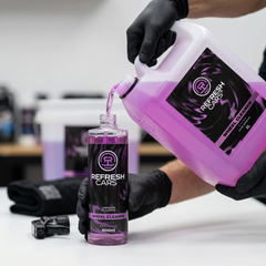 Limpia llantas Refresh Cars rosa rellenando bote 500ml desde garrafa 5L con guantes en taller