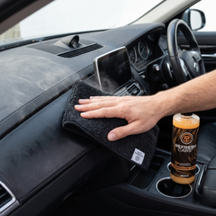 Limpiador de salpicaderos Refresh Cars extendido con paño de microfibra sobre el salpicadero del coche